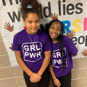 Girls posing in Girls on the Run shirts and smiling